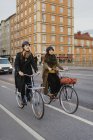 Homem e mulher de bicicleta na rua da cidade, foco seletivo — Fotografia de Stock