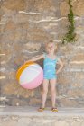 Vista frontale della ragazza in piedi con la palla — Foto stock
