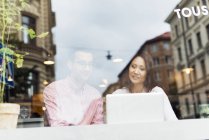 Homem e mulher conversando no café usando laptop — Fotografia de Stock