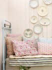 Vintage bed and wall decorated with plates — Stock Photo