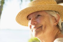 Portrait of woman with straw hat looking away — Stock Photo