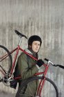 Portrait d'un homme adulte moyen tenant un vélo à engrenages fixes — Photo de stock