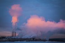 Smoke running from factory pipes at sunset — Stock Photo