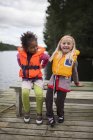 Duas meninas vestindo coletes salva-vidas, foco em primeiro plano — Fotografia de Stock