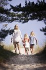 Mother with son and daughters walking along footpath — Stock Photo