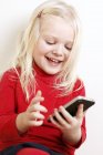 Menina sorrindo usando telefone celular — Fotografia de Stock