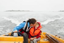Вид спереди матери и сына на моторной лодке — стоковое фото