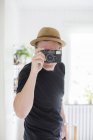 Man wearing straw hat looking through camera — Stock Photo