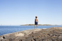 Visão traseira do menino olhando para o mar — Fotografia de Stock