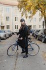 Young man standing with bicycle, selective focus — Stock Photo