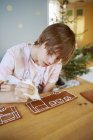 Мальчик украшает печенье, сосредоточиться на переднем плане — стоковое фото