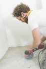 Man renovating house, focus on foreground — Stock Photo