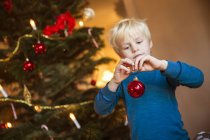 Little blonde boy with Christmas decoration toy — Stock Photo