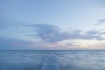 Вид спереду морський пейзаж з пірсом на заході сонця — стокове фото