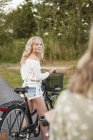 Two teenage girls with bicycles, selective focus — Stock Photo