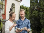 Двоє чоловіків читають книгу, вибірковий фокус — стокове фото