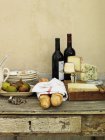Cheese wedges, wine and bread on table — Stock Photo