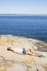 Вид збоку жінки, що розслабляється біля моря — стокове фото