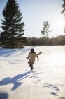 Девушка ходит по снегу в солнечный день — стоковое фото