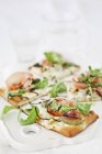 Pizza mit Ziegenkäsecreme, Rucola, Pinienkernen, Feigen und Parmaschinken — Stockfoto