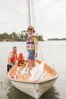 Família com criança vestindo coletes salva-vidas em veleiro no rio — Fotografia de Stock