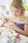 Girl painting easter egg, differential focus — Stock Photo