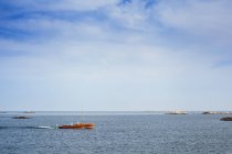 Barca in movimento sul mare sotto cielo nuvoloso blu — Foto stock