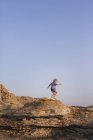 Vista lateral da menina caminhadas na formação de rocha — Fotografia de Stock