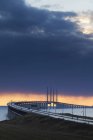 Vista del puente de Oresund bajo el cielo dramático al atardecer - foto de stock