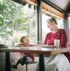 Großmutter und Enkelin entspannen im Café, Fokus auf den Vordergrund — Stockfoto