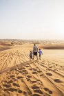Отец с сыновьями, идущими по пустыне — стоковое фото