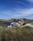 Huts on grassy beach in bright sunlight — Stock Photo