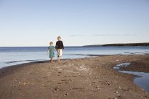 Hermano con hermana caminando por la costa báltica - foto de stock