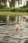 Chica en el lago secando los ojos con las manos, enfoque selectivo - foto de stock