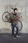 Чоловік середнього віку тримає велосипед з фіксованою передачею — стокове фото
