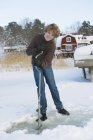 Portrait of teenager making hole for ice fishing — Stock Photo