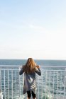 Menina de pé na balsa, visão traseira — Fotografia de Stock