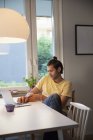Hombre sentado en el apartamento y el uso de ordenador portátil, enfoque selectivo - foto de stock