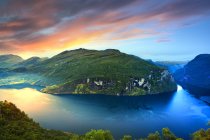 Blick auf See und Berge unter Sonnenaufgangshimmel — Stockfoto