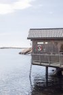 Cabaña de madera con salvavidas en la pared sobre el mar - foto de stock