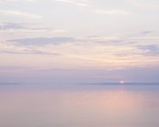 Vista panorâmica da paisagem marinha do pôr-do-sol sob céu nublado — Fotografia de Stock
