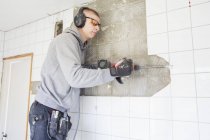 Young man in protective eyewear renovating house — Stock Photo