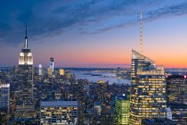 New York City skyscrapers illuminated under sunset sky — Stock Photo
