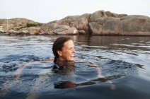 Donna che nuota in mare e distoglie lo sguardo — Foto stock