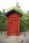 Vista de vermelho colorido banheiro ao ar livre de madeira — Fotografia de Stock