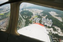 Blick auf Land mit Gebäuden durch Flugzeugfenster — Stockfoto