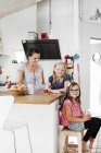 Mãe e filhas sorrindo na cozinha — Fotografia de Stock
