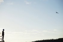 Silhouette eines Mannes, der auf eine gegen den Himmel stehende Mörtelplatte blickt — Stockfoto