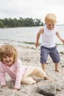 Вид спереди девочки и мальчика на пляже — стоковое фото