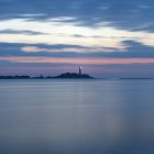 Морской пейзаж с маяком, освещенным в сумерках — стоковое фото